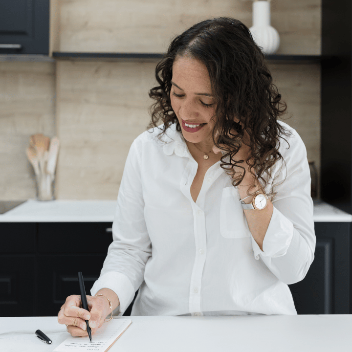 Audrey, home organiser à Reims, écrivant dans un carnet dans une cuisine moderne