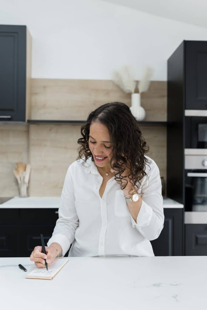 Audrey, home organiser à Reims, prenant des notes dans une cuisine moderne et épurée.