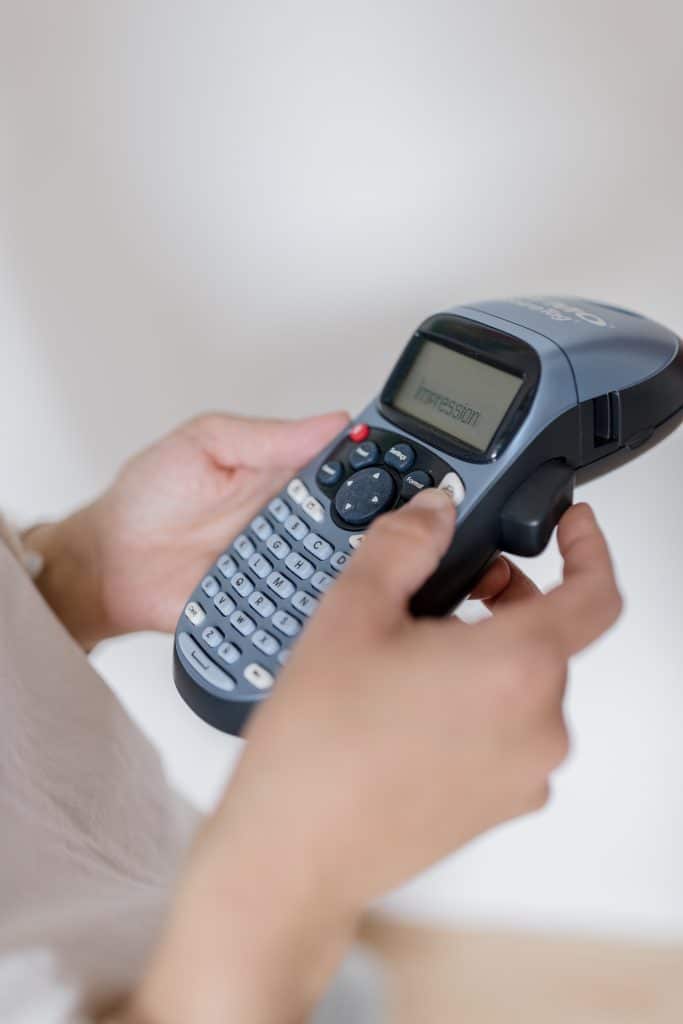 Gros plan sur une étiqueteuse Dymo utilisée pour ranger et identifier les objets à la maison.